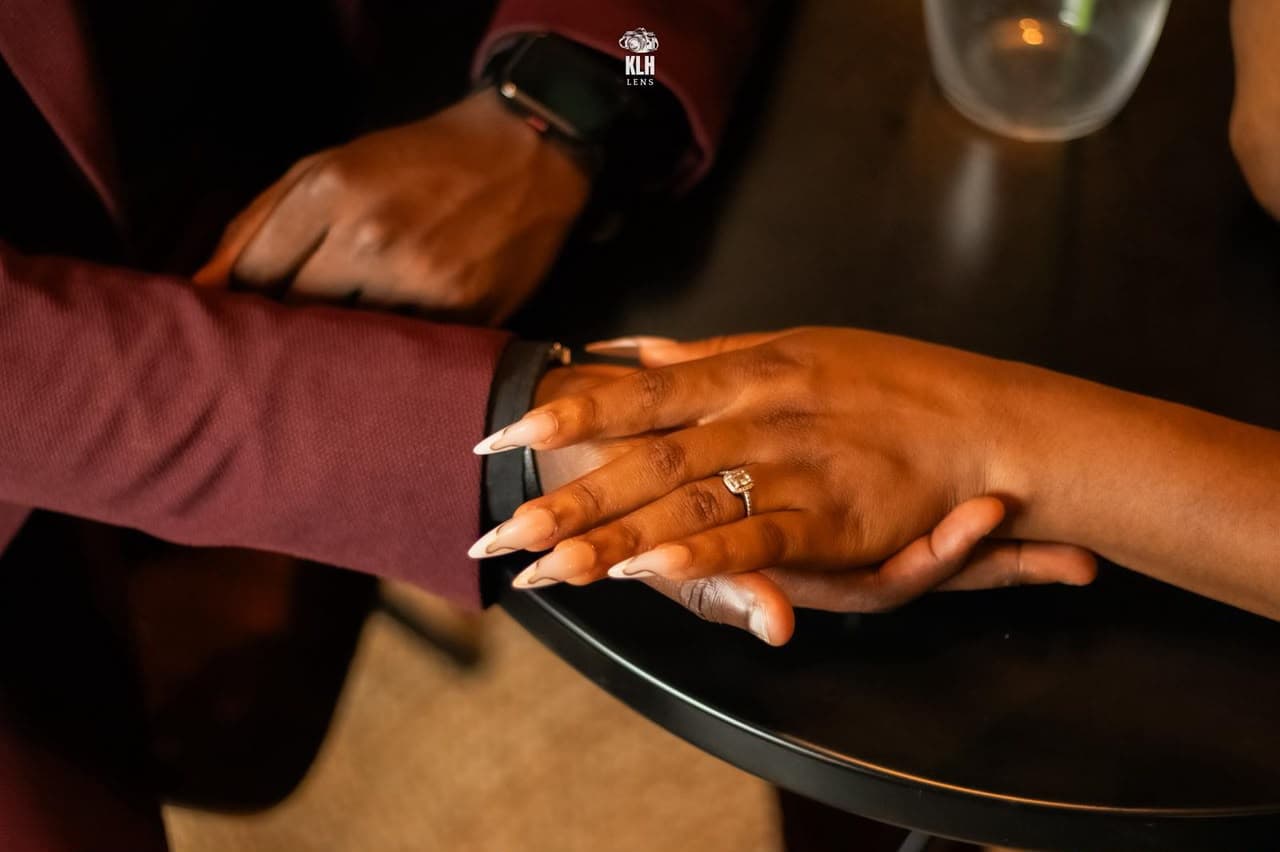 Leurs mains posées l'une sur l'autre, la bague de fiançailles au doigt